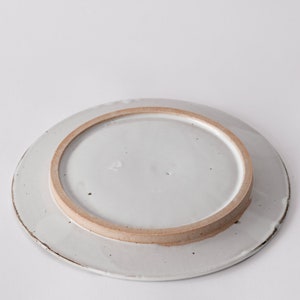 handmade stoneware dinner plate, two tone warm black and white glazes overlapping creating a gradient of warm earthy grays in between.