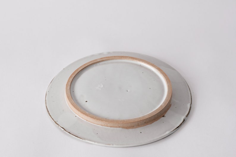 handmade stoneware dinner plate, two tone warm black and white glazes overlapping creating a gradient of warm earthy grays in between.