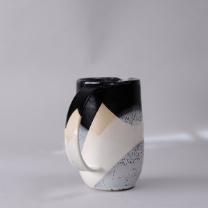 beautiful handmade ceramic water jug or pitcher. Decorated with black and white overlapping glazes which create a modern geometric pattern.