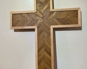 May include: A wooden cross with a herringbone pattern in the center and a light wood frame.