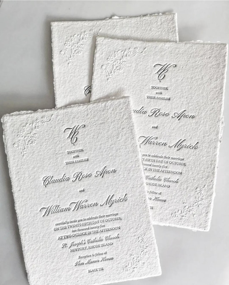 May include: White wedding invitations with embossed floral corner designs and elegant script. The invitations include the names Claudia Rose Apon and William Warren Myrick, along with event details.