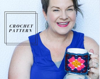 May include: A woman wearing a blue tank top and jeans is holding a white mug with a crocheted cozy. The cozy is a colorful granny square pattern with pink, yellow, and burgundy colors. The text "CROCHET PATTERN" is in a black box in the upper left corner of the image.