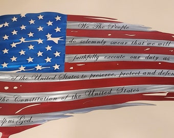 May include: A distressed American flag metal wall art with the words "We The People" and the preamble to the Constitution of the United States.