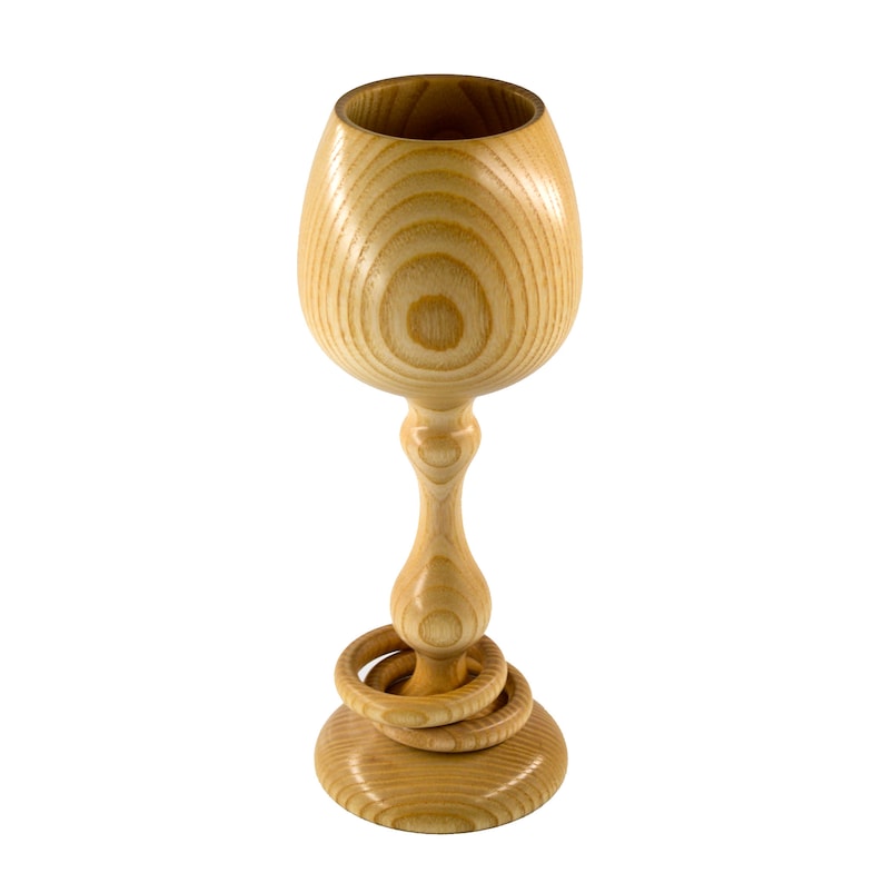 A round wooden traditional Irish wedding goblet on a white background with two captive wooden rings around its stem. It is handmade in Ireland from native Irish Ash wood. It has distinctive grain and is 10 inches tall by 4 inches in diameter.