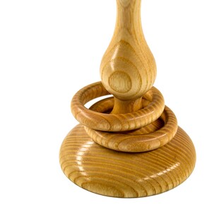 Close up of two wooden captive rings around the base of a tradtional Irish wedding goblet. The wooden goblet is made from native Irish Ash from County Galway, and displays distinctive grain. It also has a glossy finish and is on a white background.