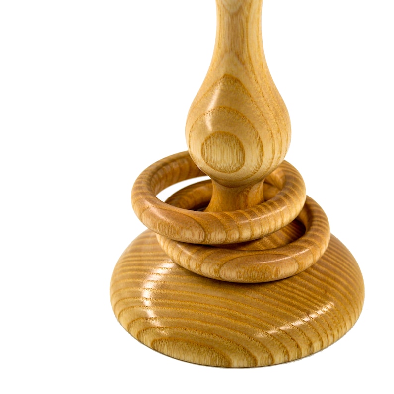 Close up of two wooden captive rings around the base of a tradtional Irish wedding goblet. The wooden goblet is made from native Irish Ash from County Galway, and displays distinctive grain. It also has a glossy finish and is on a white background.
