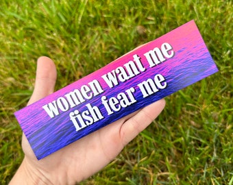 May include: A sticker with a pink and blue gradient background and the text "women want me fish fear me" in white.