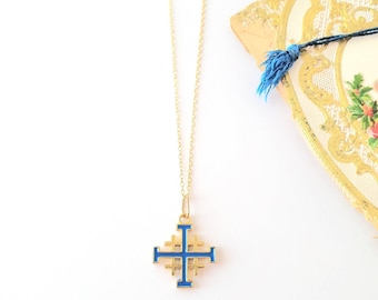 May include: A gold chain necklace with a blue enamel cross pendant. The cross is a Jerusalem cross with a intricate design.