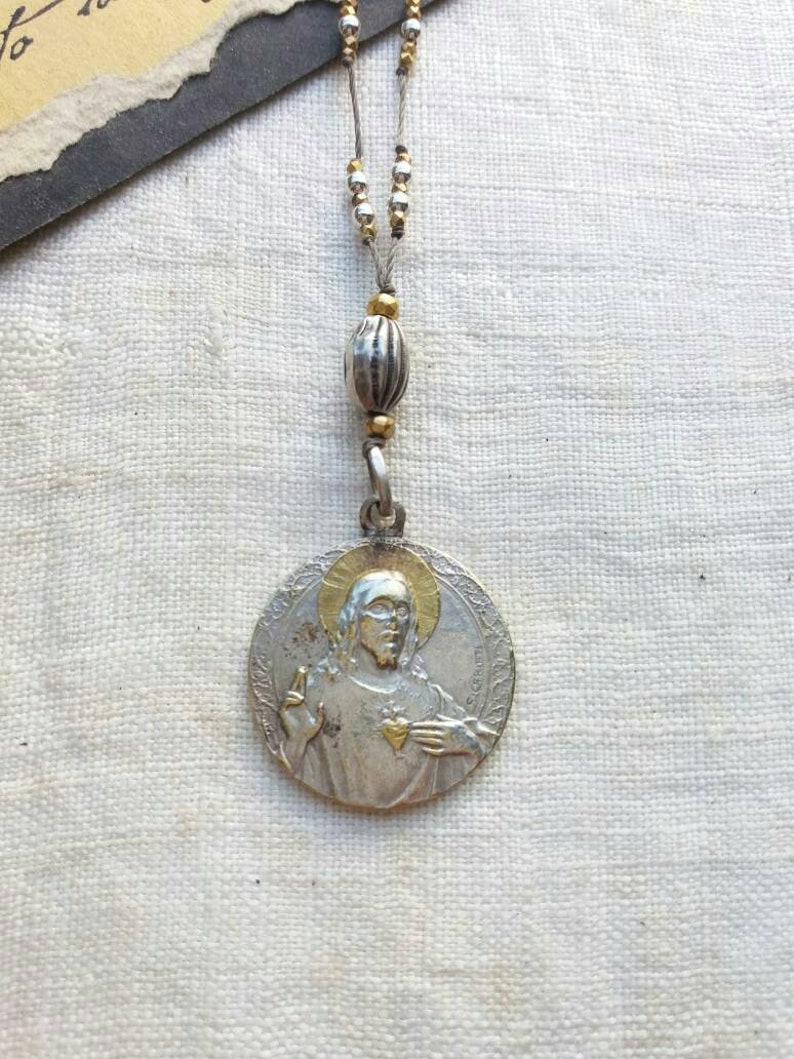 Antique silver and gold sacred heart necklace .