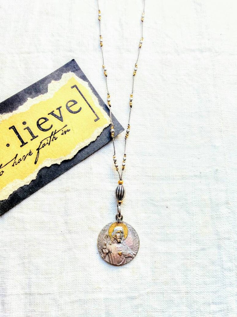 Antique silver and gold sacred heart necklace .