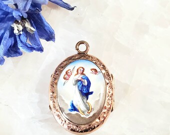 May include: Oval gold locket with an enamel portrait of the Virgin Mary surrounded by two angels. The locket has a detailed floral design around the edge.