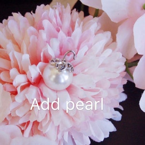 May include: A white pearl with a silver setting is placed on a pink flower. The text "Add pearl" is written below the pearl.