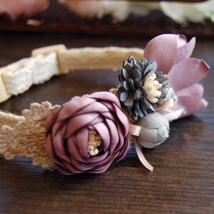 May include: A delicate brown and white lace dog collar with a purple flower and gray flower embellishment.
