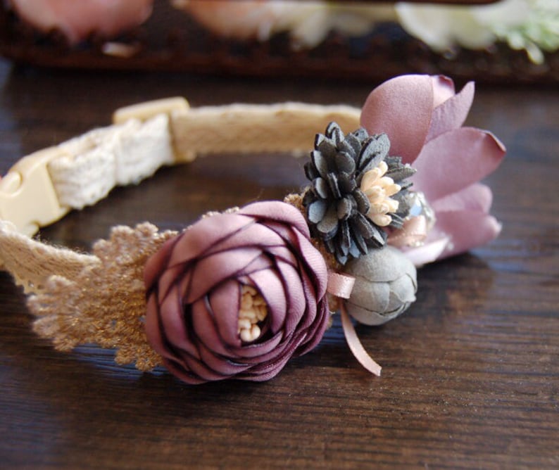 May include: A delicate brown and white lace dog collar with a purple flower and gray flower embellishment.