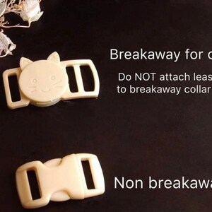 May include: Two plastic cat collar buckles. One is a breakaway buckle with a cat face design. The other is a non-breakaway buckle. The text "Breakaway for cat" and "Do NOT attach leash to breakaway collar!" is printed above the breakaway buckle. The text "Non breakaway" is printed below the non-breakaway buckle.