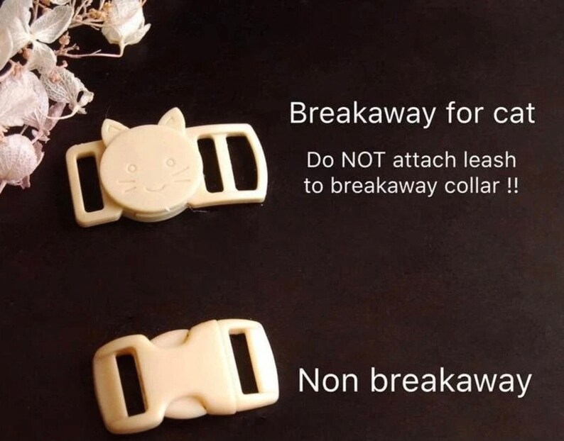 May include: Two plastic cat collar buckles. One is a breakaway buckle with a cat face design. The other is a non-breakaway buckle. The text "Breakaway for cat" and "Do NOT attach leash to breakaway collar!" is printed above the breakaway buckle. The text "Non breakaway" is printed below the non-breakaway buckle.