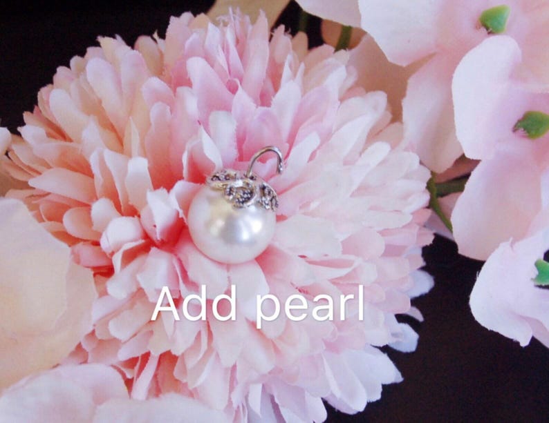 May include: A close-up of a pink flower with a pearl attached to the center. The text "Add pearl" is written below the flower.