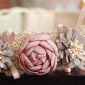 Puede incluir: Collar para mascotas de color marfil con ribete de encaje y flores de tela. Las flores son rosas, grises y crema, con pequeñas cintas rosas. El collar tiene una hebilla de plástico. El ancho del collar es de unos 2,5 cm.