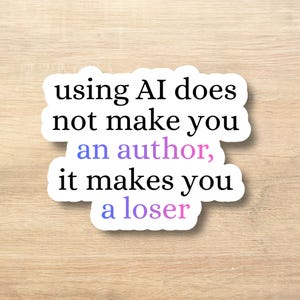 Peut inclure: Un autocollant blanc avec du texte noir qui dit "using AI does not make you an author, it makes you a loser." Les mots "an author" sont en violet et "a loser" est en rose.