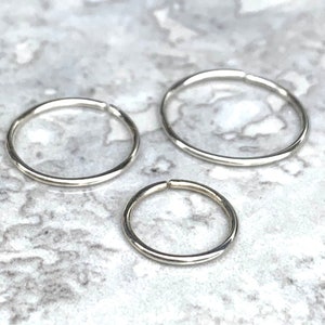 Three Class X minimalist plain sterling silver no clasp hoops in sizes 6mm, 8mm and 10mm on white and black marble tile