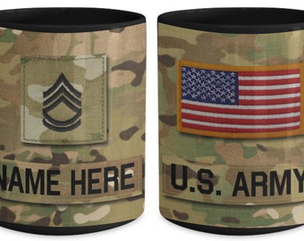 May include: Black coffee mug with a camouflage pattern. The mug has a black handle and a white inscription that reads "NAME HERE" and "U.S. ARMY". The mug also features a military rank insignia and an American flag.