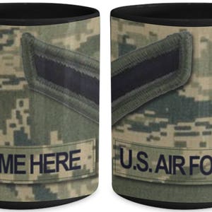 May include: A black coffee mug with a camouflage pattern and the text "NAME HERE" and "U.S. AIR FORCE".