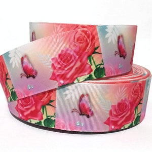 May include: Pink and white ribbon with a repeating pattern of pink roses and butterflies. The ribbon has a satin finish.