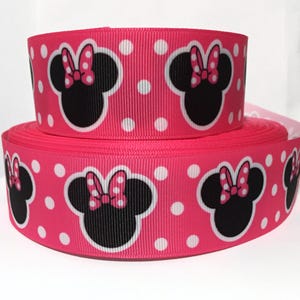 May include: Pink ribbon with white polka dots and a repeated pattern of black Minnie Mouse heads with pink bows.