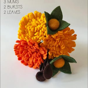 May include: A felt flower bouquet with three yellow mums, two orange bursts, and two green leaves. The bouquet is arranged on a white background. "ARRANGED BOUQUET 3 MUMS 2 BURSTS 2 LEAVES" is written in black text at the top of the image.