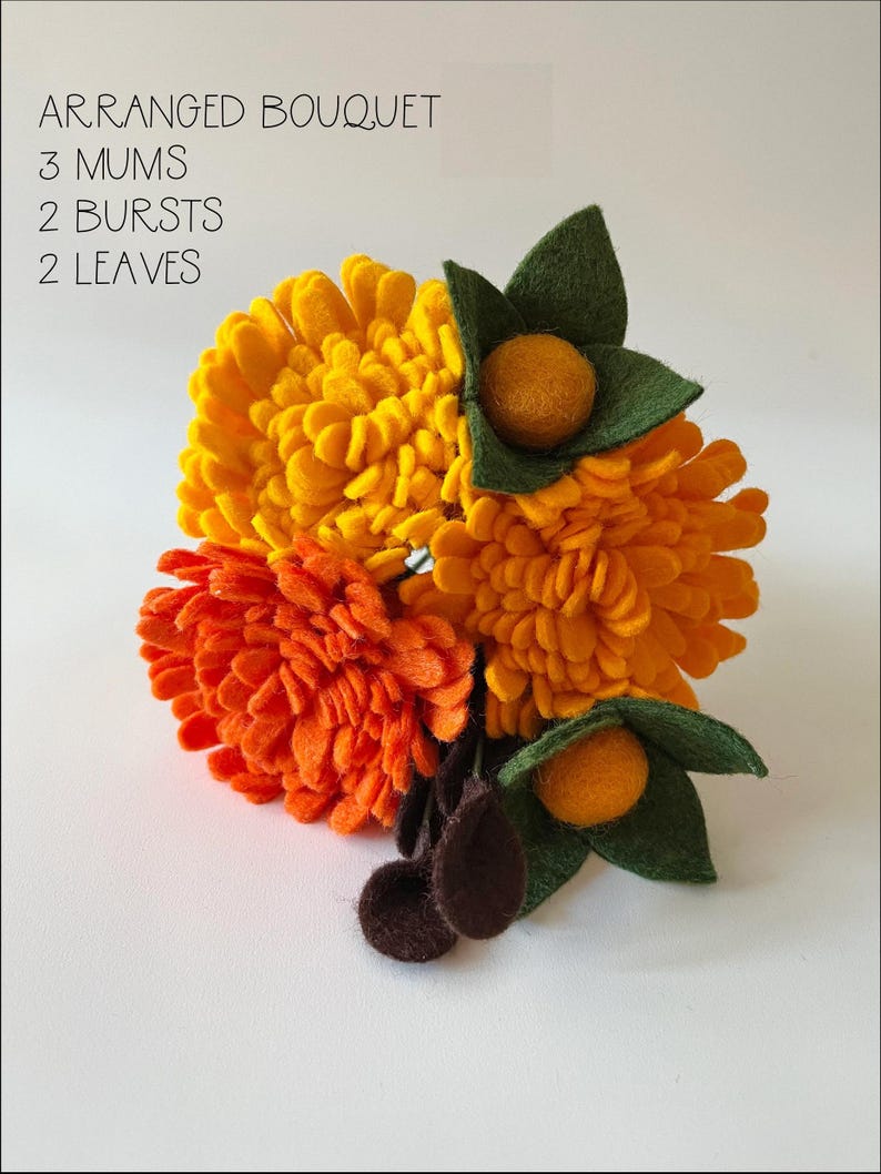 May include: A felt flower bouquet with three yellow mums, two orange bursts, and two green leaves. The bouquet is arranged on a white background. "ARRANGED BOUQUET 3 MUMS 2 BURSTS 2 LEAVES" is written in black text at the top of the image.