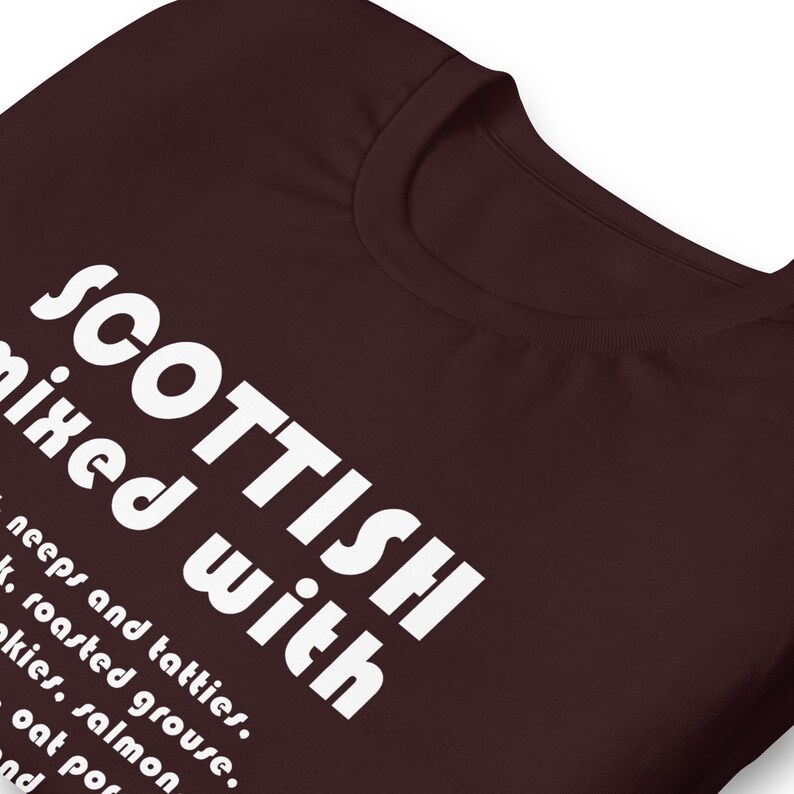 Może przedstawiać: Ciemnobrązowy t-shirt z białym tekstem, kt&oacute;ry brzmi "SCOTTISH mixed with neeps and tatties, roasted grouse, akies, salmon, oat por, and"