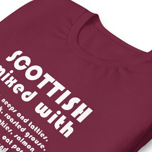 Może przedstawiać: Bordowy t-shirt z białym napisem "SCOTTISH mixed with neeps and tatties, roasted grouse, kkies, salmon, oat por and"