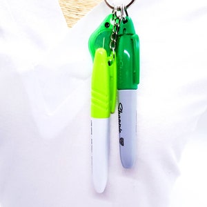 May include: A keychain with a green highlighter, a gray Sharpie marker, and a green key chain charm.