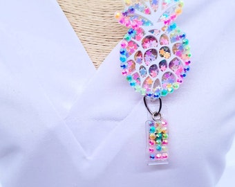 May include: A white pineapple-shaped badge holder with rainbow glitter and a clear, rainbow-colored badge clip.