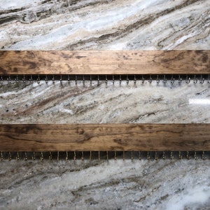 Puede incluir: Dos organizadores de joyas de madera con ganchos de metal. Cada organizador tiene un acabado te&ntilde;ido de color marr&oacute;n oscuro y mide aproximadamente 40 cm de largo.