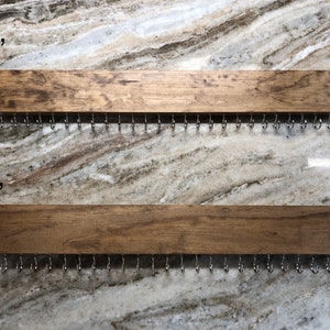 Puede incluir: Dos organizadores de joyas de madera con ganchos de metal. El organizador superior mide 61 cm de largo y el organizador inferior mide 46 cm de largo.