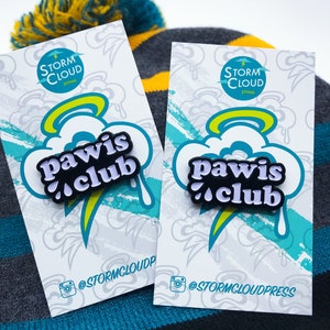 Peut inclure: Deux cartes blanches avec un motif bleu et jaune repr&eacute;sentant une &eacute;pingle en &eacute;mail noir et blanc avec le texte "Pawis Club" sur un nuage blanc avec une aur&eacute;ole jaune. Les cartes portent le texte "Storm Cloud Press" et le nom d'utilisateur Instagram "@stormcloudpress".