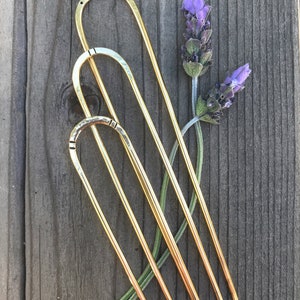 Brass hairpins in different stamped designs.