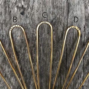 Brass hairpins in different stamped designs.