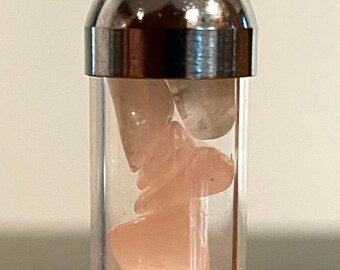 May include: A silver pendant necklace with a clear glass tube containing pink rose quartz stones.
