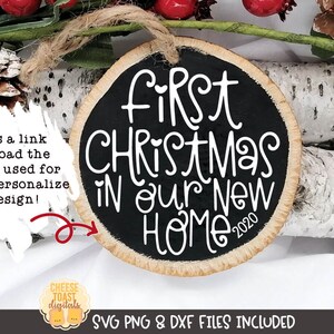 May include: A round wooden ornament with a black background and white text that reads "First Christmas in our new home 2020".