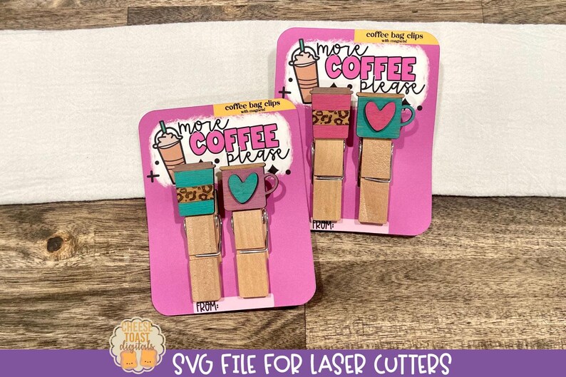 May include: Two pink cards with the text "more coffee please" and a coffee cup design. Each card has two wooden clothespins with a coffee cup and heart design.