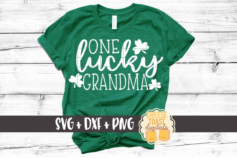 May include: Green t-shirt with white text that reads "One lucky grandma" with shamrock designs. The shirt is tied in a knot at the bottom.