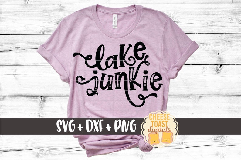 May include: A pink t-shirt with the text "lake junkie" in black script font. The shirt is on a white wood background. The text "SVG + DXF + PNG" is at the bottom of the image.