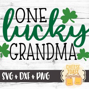May include: Green shamrock leaves surround the text "One lucky grandma" in black lettering on a white wood background. The text "SVG + DXF + PNG" is in black lettering on a gray background. A logo for "Cheese Toast Digitals" is in the bottom right corner.