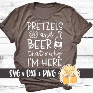 以下が含まれることがあります： 白い文字で「Pretzels and Beer that's why I'm here」と書かれた茶色のTシャツ。Tシャツにはプレッツェルとビール瓶のグラフィックが描かれている。Tシャツの下部には「SVG + DXF + PNG」という文字が書かれている。Tシャツの右下には円の中に「CHEESE TOAST digitals」という文字が書かれている。
