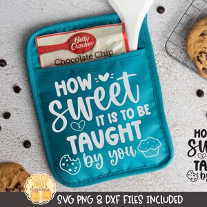 以下が含まれることがあります： ターコイズブルーのオーブンミットに、白い文字で「HOW sweet IT IS TO BE TAUGHT by you」と書いてあります。ミットの前方にはポケットがあり、中にベティ・クロッカーのチョコレートチップ入りベーキングミックスのパケットが入っています。