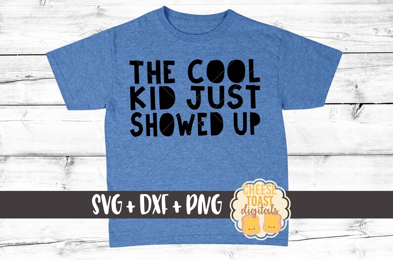 May include: Blue t-shirt with the text "The Cool Kid Just Showed Up" in black. The shirt has a white graphic of two pieces of toast with the text "Cheese Toast Digitals" in black.