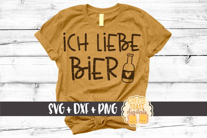 以下が含まれることがあります： マスタードイエローのTシャツに「ICH LIEBE BIER」の文字と、ハートの付いたビール瓶のシルエットが描かれています。「SVG + DXF + PNG」の文字がTシャツの下部にあり、「CHEESE TOAST DIGITALS」の文字が画像の右下に円形で表示されています。