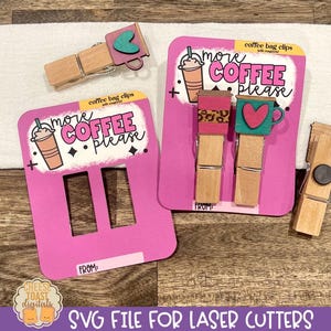 May include: Two pink and white cards with the text "more coffee please" and a coffee cup graphic. The cards are designed to be used as coffee bag clips. A wooden clothespin with a black circle is also shown.